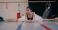 Die Tänzerin Shaelynn Estrada beboachtet in ihrer Pause die Kolleginnen im Ballettsaal. © Videoausschnitt „Swan Song“
