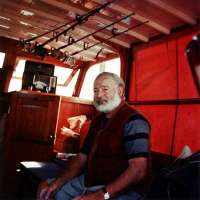 Ernest Hemingway, Gregorys Vater, 1950 auf seinem schwarzen Fischerboot Pilar. Mit seinen beiden Motoren+ sechs Schlaplätzenlg die Pilar meist in Cojimar, Kuba vor Anker. © Public domain