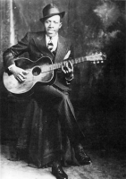  Robert Johnson, Schöpfer des  „Walkin` Blues“, aufgenommen  um 1936. © 1989 Delta Haze Corporation [2] The photograph was taken in 1936 by the Hooks Brothers Photographers studio, owned by Henry and Robert Hooks, located on Beale Street in Memphis. / wikipedia