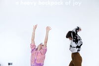 Karin Pauer, Charlotta Ruth: A heavy backpack of joy, sagt die Schrift an der Wand, doch sie tragen ihn leicht, den schweren Rucksack voll Freude. 
